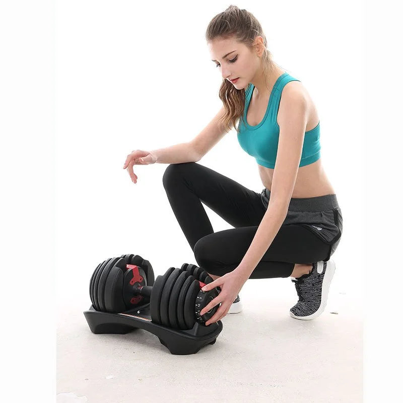 Woman adjusting weights on an adjustable dumbbell set in a home gym setting.