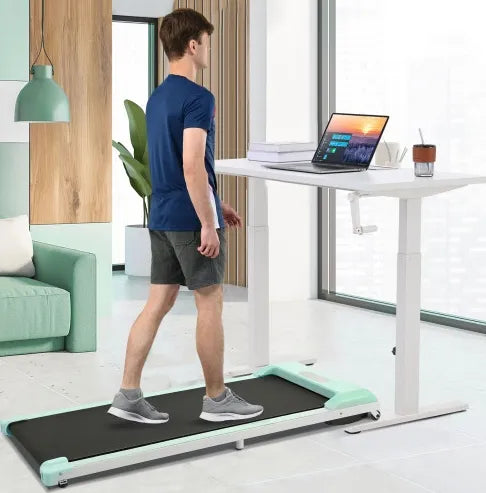 Under desk electric treadmill with man walking near standing desk in modern home office.